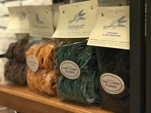 Verschiedene Algenfasern in natürlichen Farben wie Grün, Braun und Orange in Ballen verpackt.